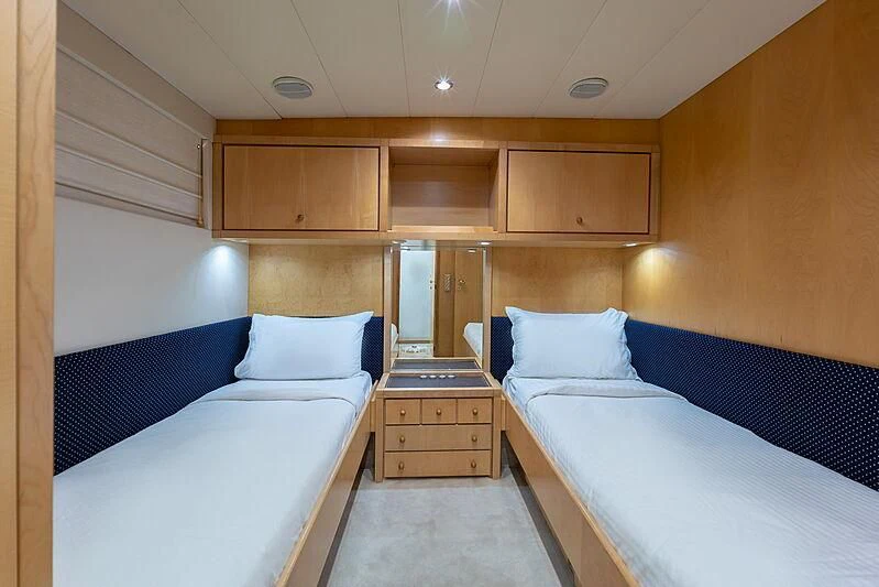 a room with beds and a dresser aboard AJAO Yacht for Sale