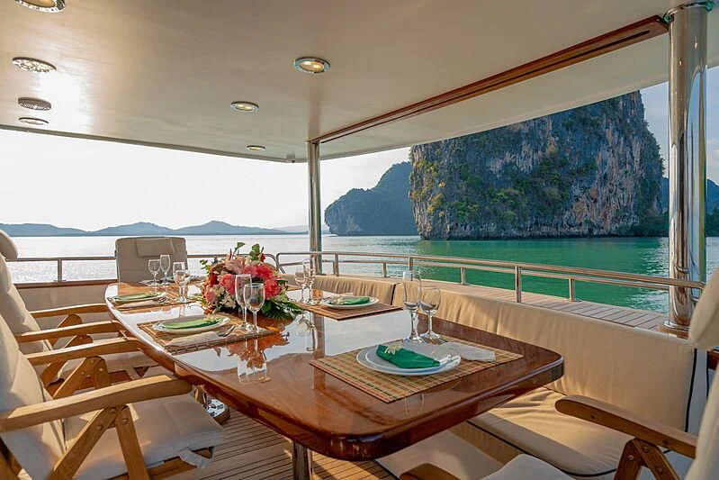 a table with chairs and a view of the ocean aboard AJAO Yacht for Sale