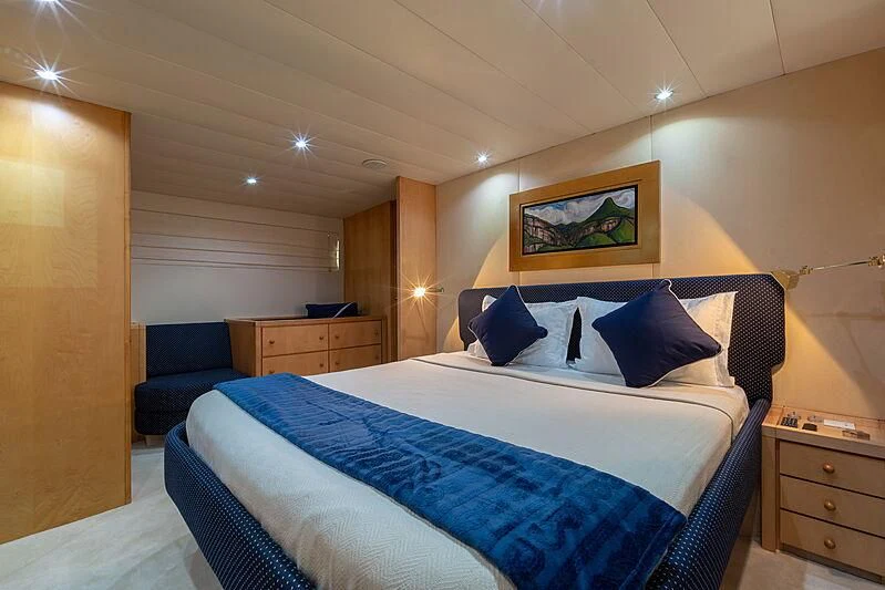 a bed with blue sheets aboard AJAO Yacht for Sale
