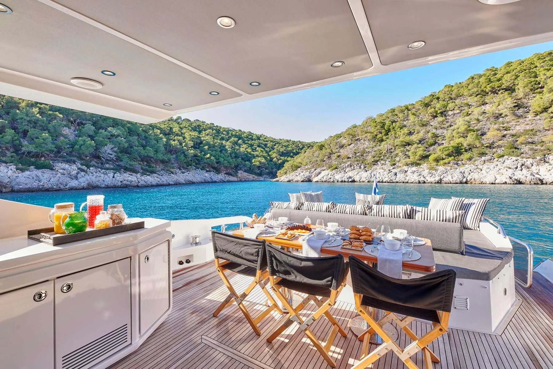 a table and chairs on a deck overlooking a body of water aboard ALKYONE Yacht for Sale