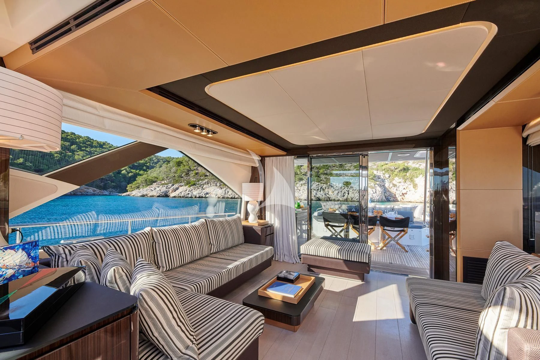a room with a bed and a table and a view of the water aboard ALKYONE Yacht for Sale