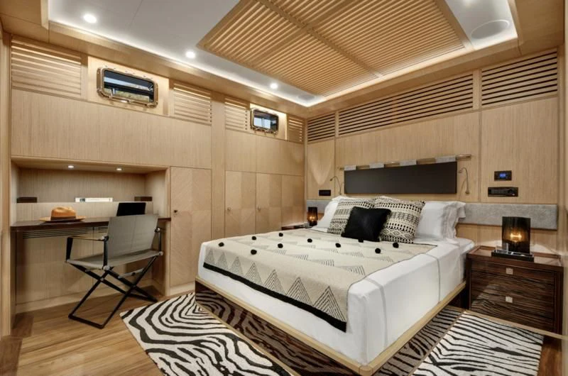 a room with a bed and desk aboard THAT'S AMORE Yacht for Sale