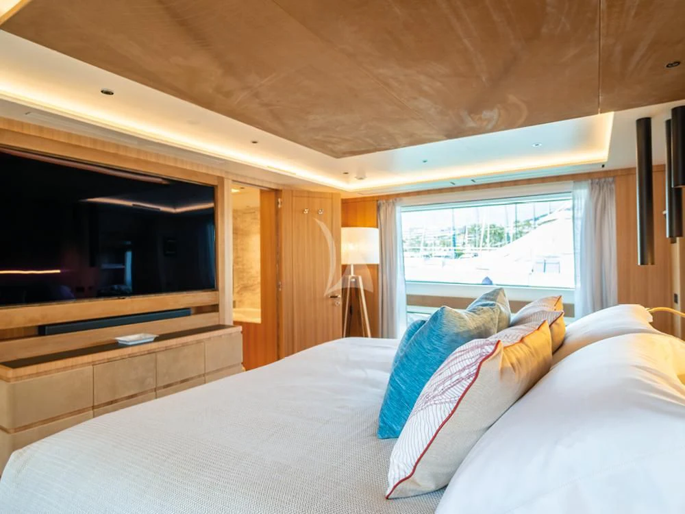 a bed with a white sheet and pillows aboard ADVA Yacht for Sale