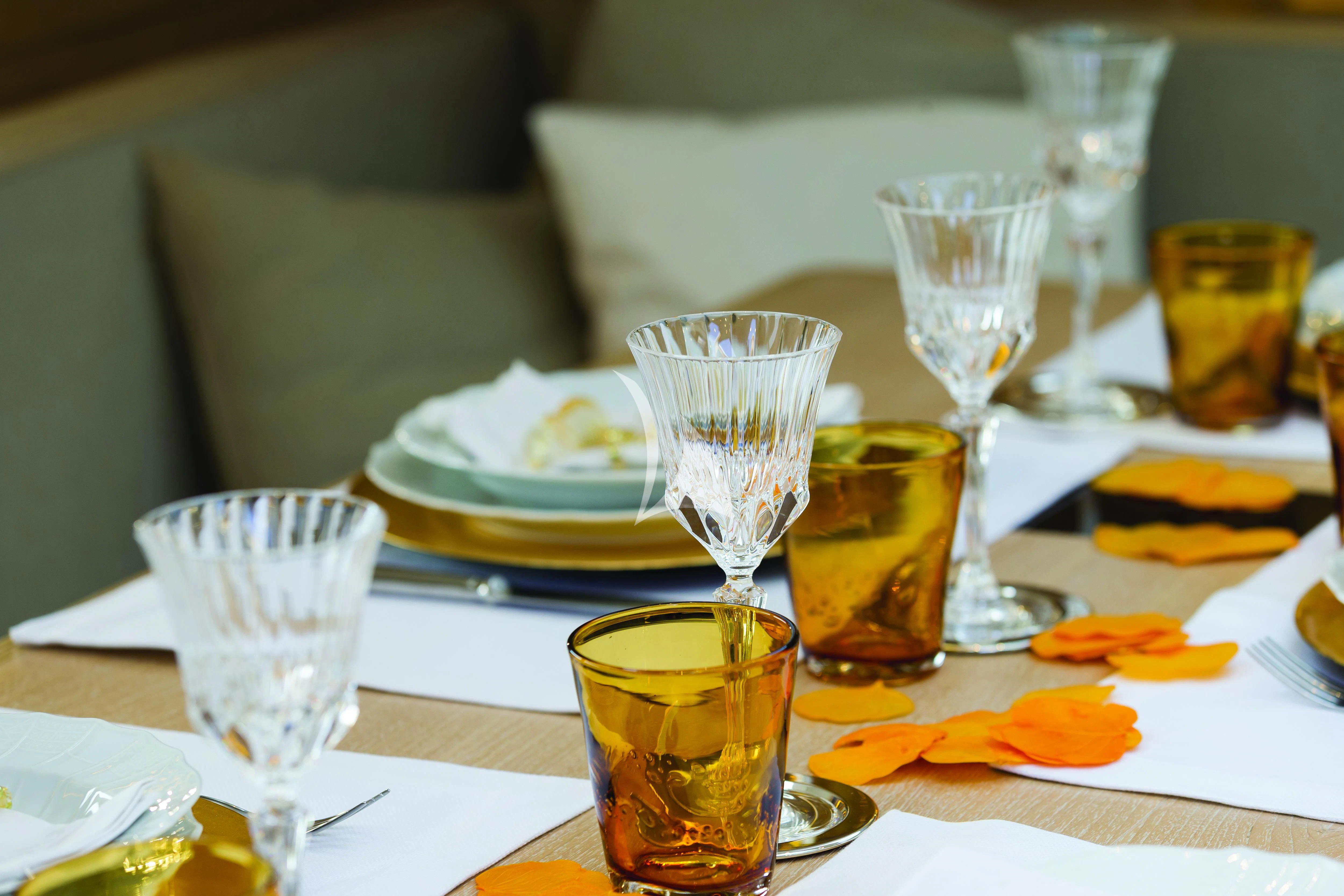 a table with plates and glasses on it aboard MINDFULNESS Yacht for Charter