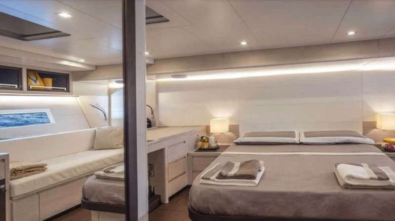 a room with a bed and a desk aboard MINDFULNESS Yacht for Charter