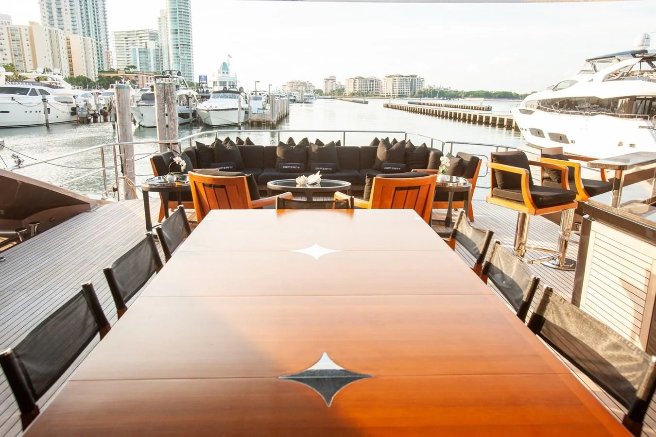 a table with chairs on it next to a large body of water aboard DEFIANT Yacht for Sale
