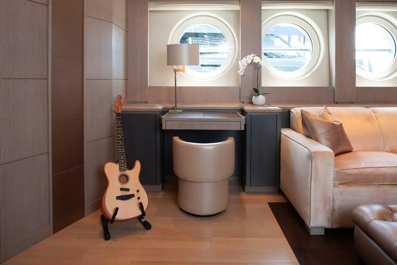 a guitar on a stand in a living room aboard DEFIANT Yacht for Sale
