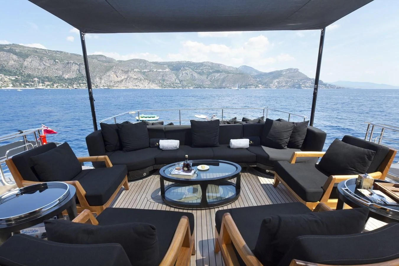 a table with chairs on it next to a large body of water aboard DEFIANT Yacht for Sale