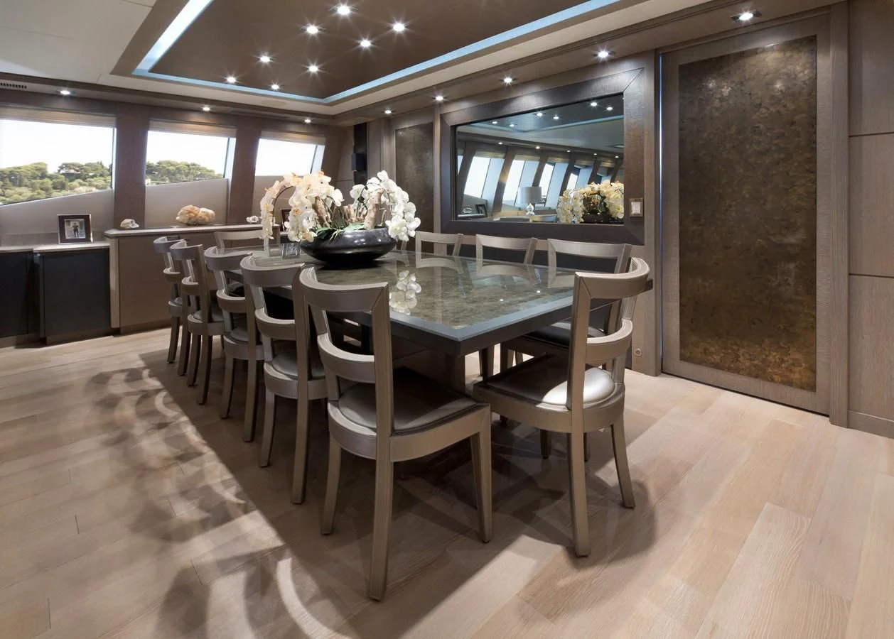 a room with tables and chairs aboard DEFIANT Yacht for Sale
