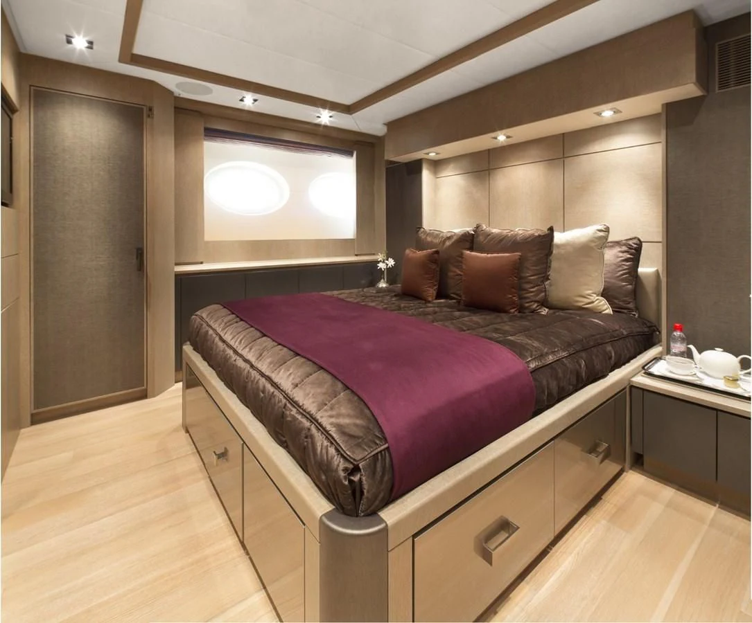 a bed with a purple comforter aboard DEFIANT Yacht for Sale
