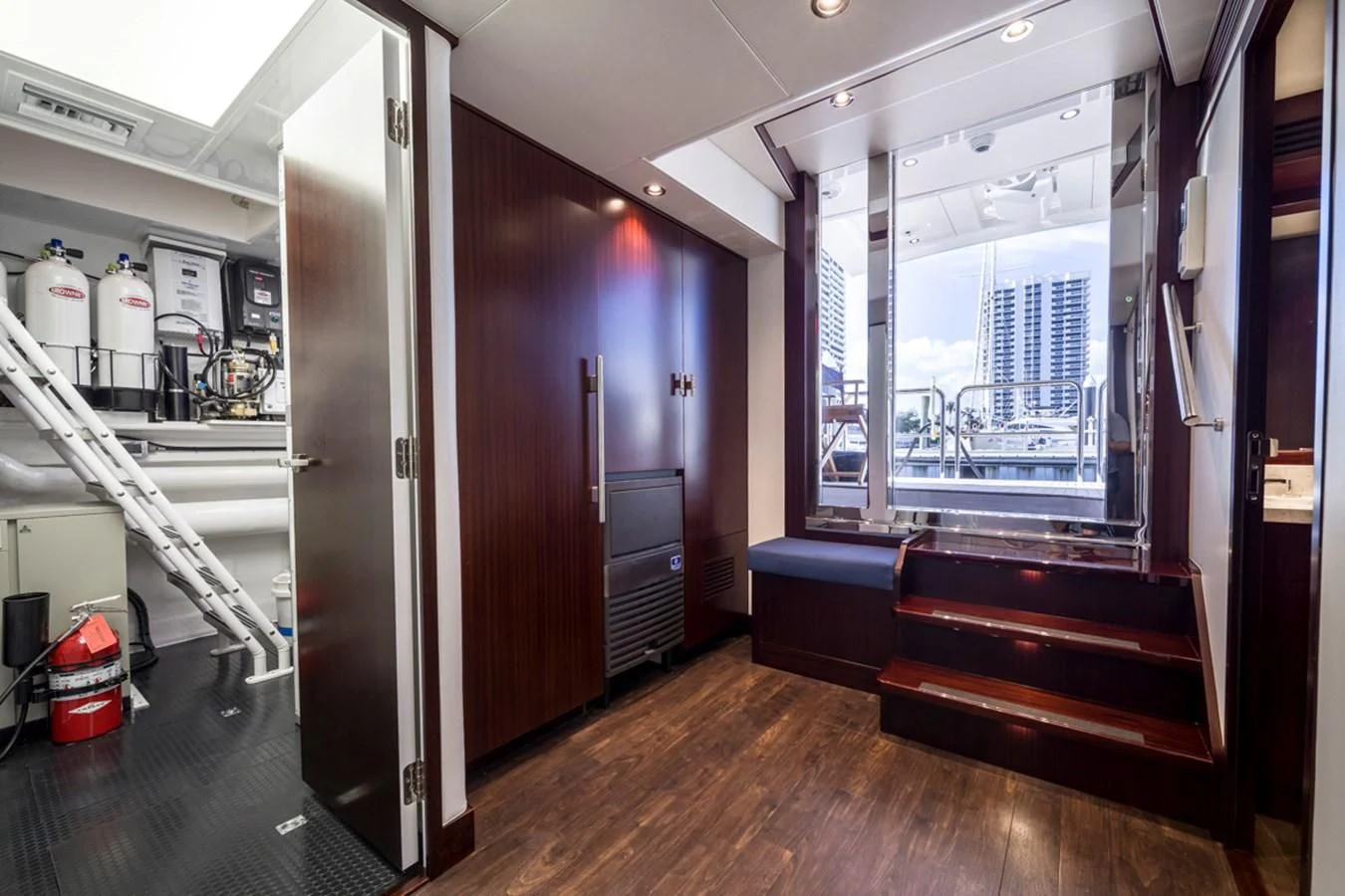 a room with a wood floor and a bench and a window aboard LION'S DEN Yacht for Sale
