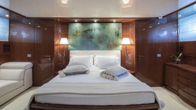 a bed with white sheets and pillows aboard MIRI Yacht for Sale
