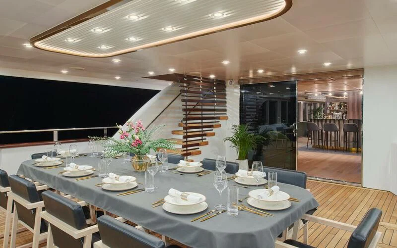a dining room with a set of tables and chairs aboard ANIMA MARIS Yacht for Sale