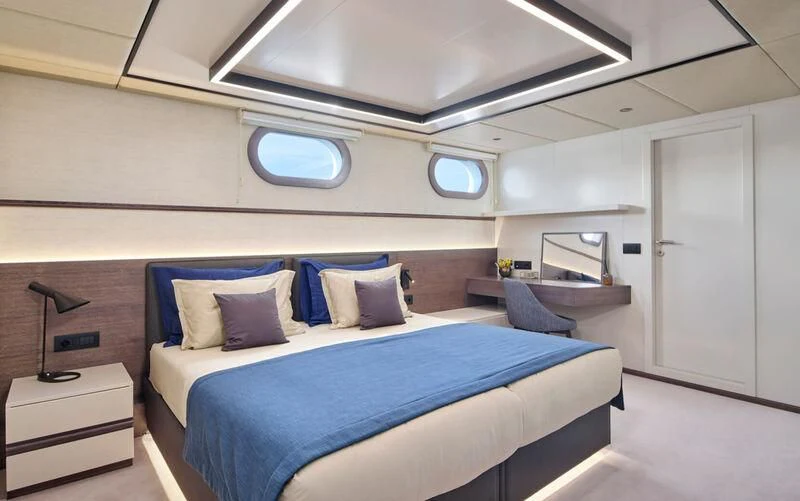 a room with a bed and a desk aboard ANIMA MARIS Yacht for Sale