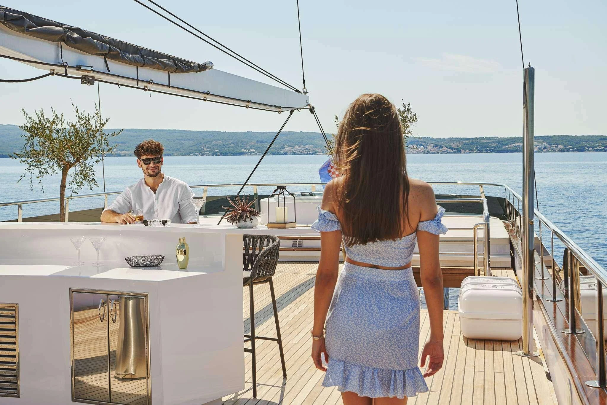 a man and woman sitting on a deck overlooking a body of water aboard ANIMA MARIS Yacht for Sale