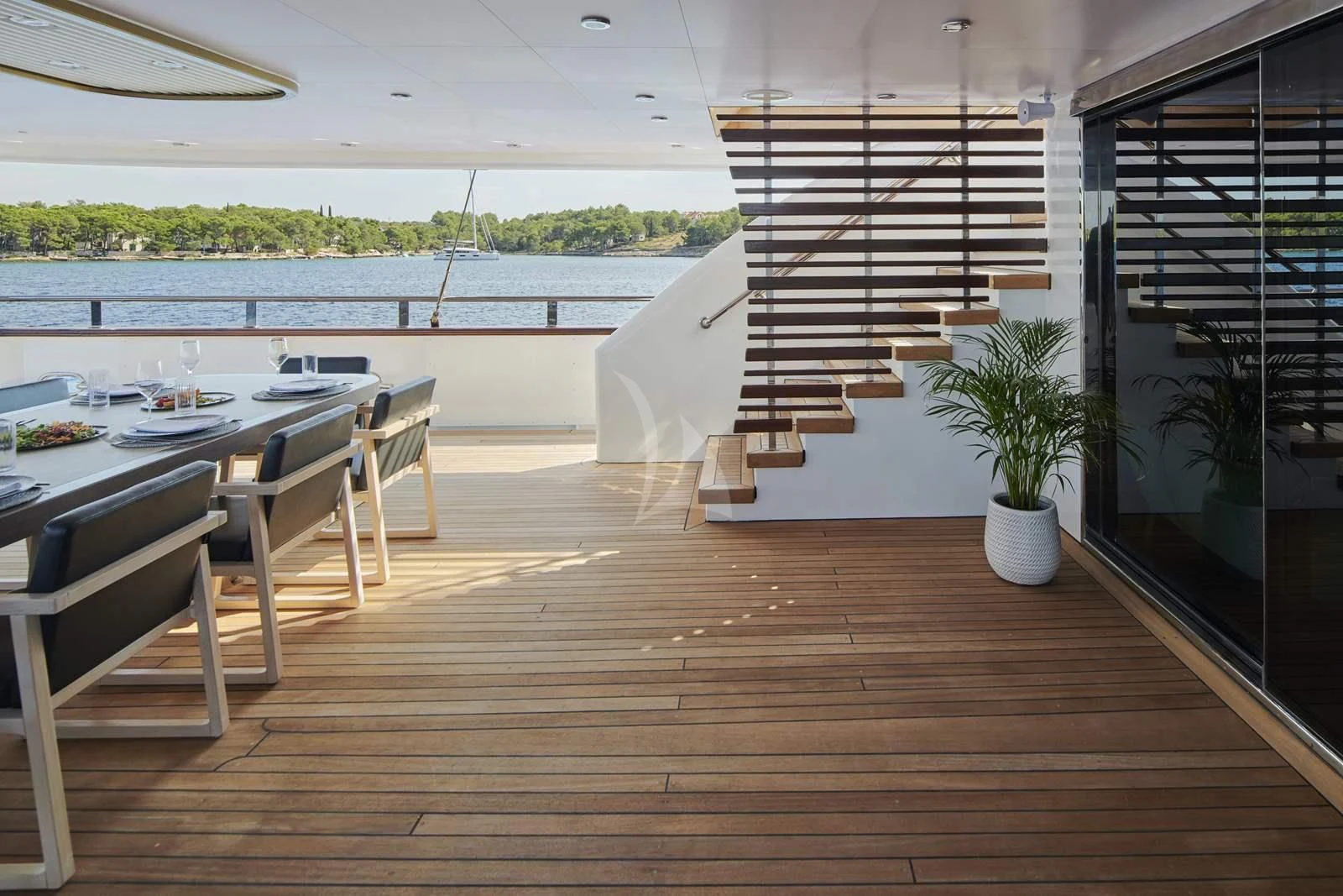 a wooden deck with a table and chairs aboard ANIMA MARIS Yacht for Sale