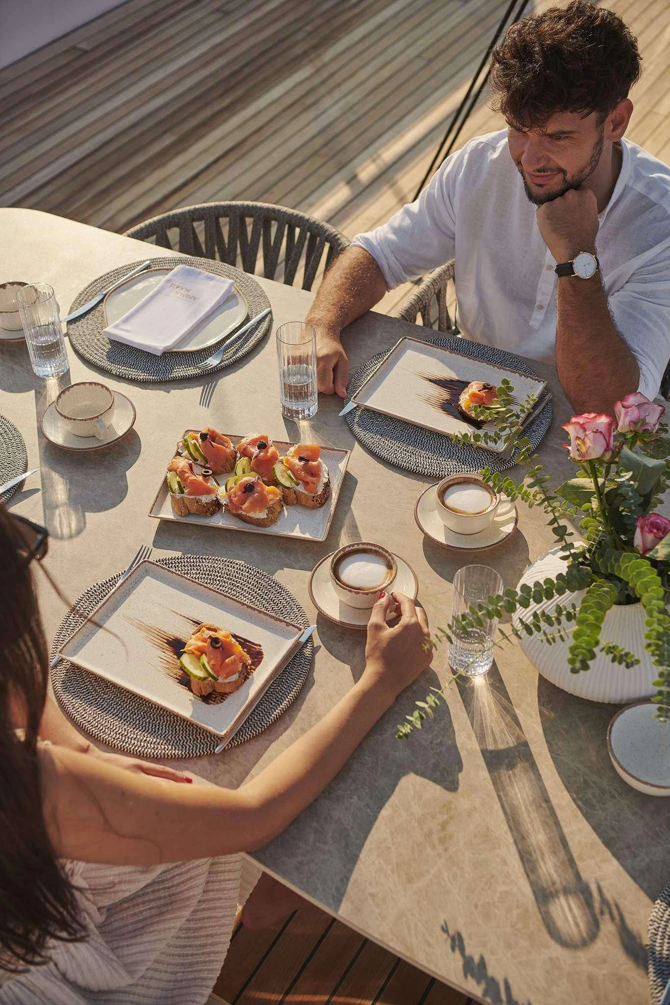 a man sitting at a table with food and drinks aboard ANIMA MARIS Yacht for Sale