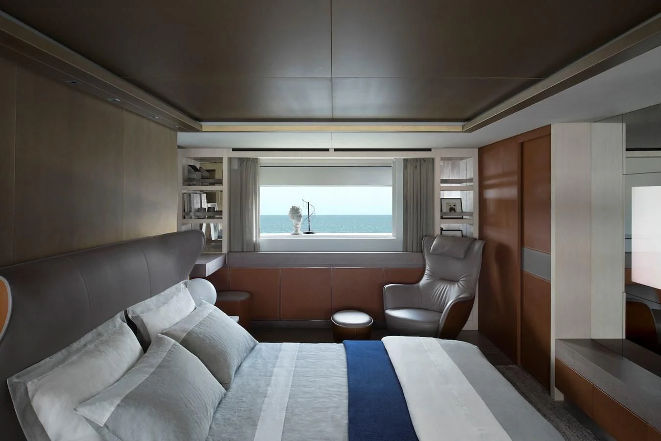 a bedroom with a bed and a chair aboard NADHIRA Yacht for Sale
