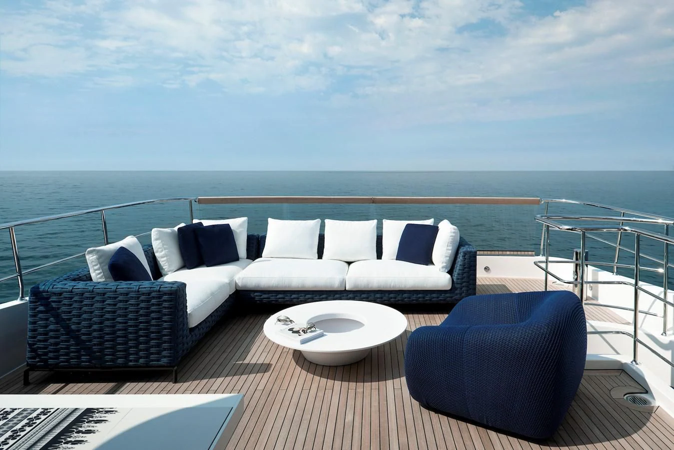 a white couch and a table on a balcony overlooking a large body of water aboard NADHIRA Yacht for Sale