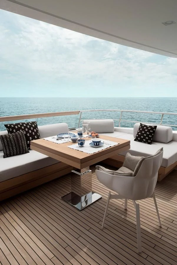 a table and chairs on a deck overlooking the ocean aboard NADHIRA Yacht for Sale