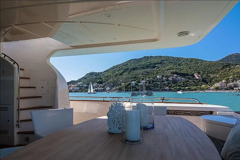 a table with chairs on it next to a body of water aboard RURI Yacht for Sale