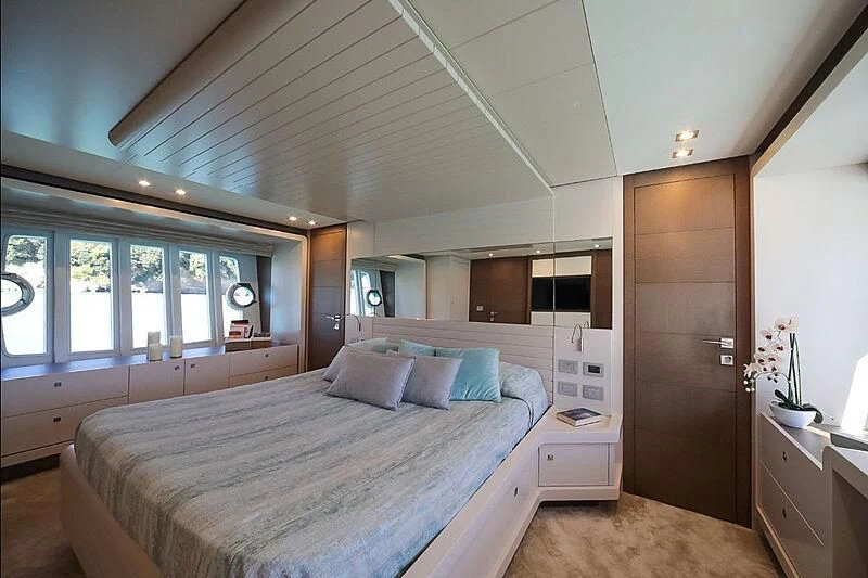 a bedroom with a bed and a wood door aboard RURI Yacht for Sale