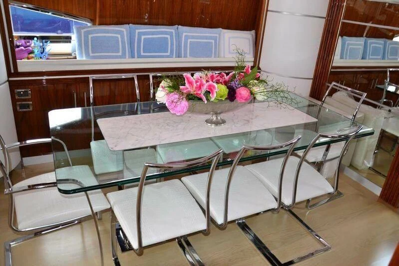 a table with chairs and flowers aboard HITECH RACING Yacht for Sale