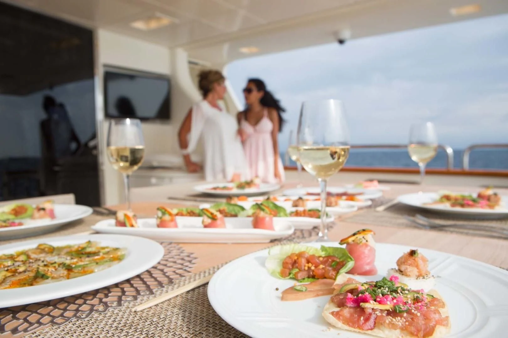 a table with plates of food and wine glasses aboard AMANECER Yacht for Sale