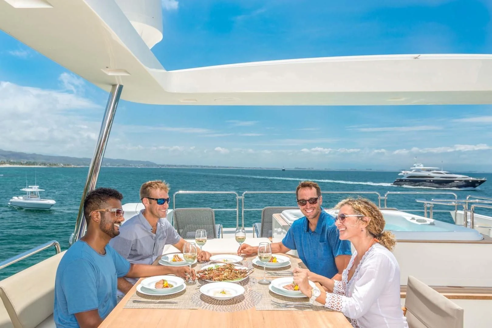 a group of people sitting at a table with food on it aboard AMANECER Yacht for Sale
