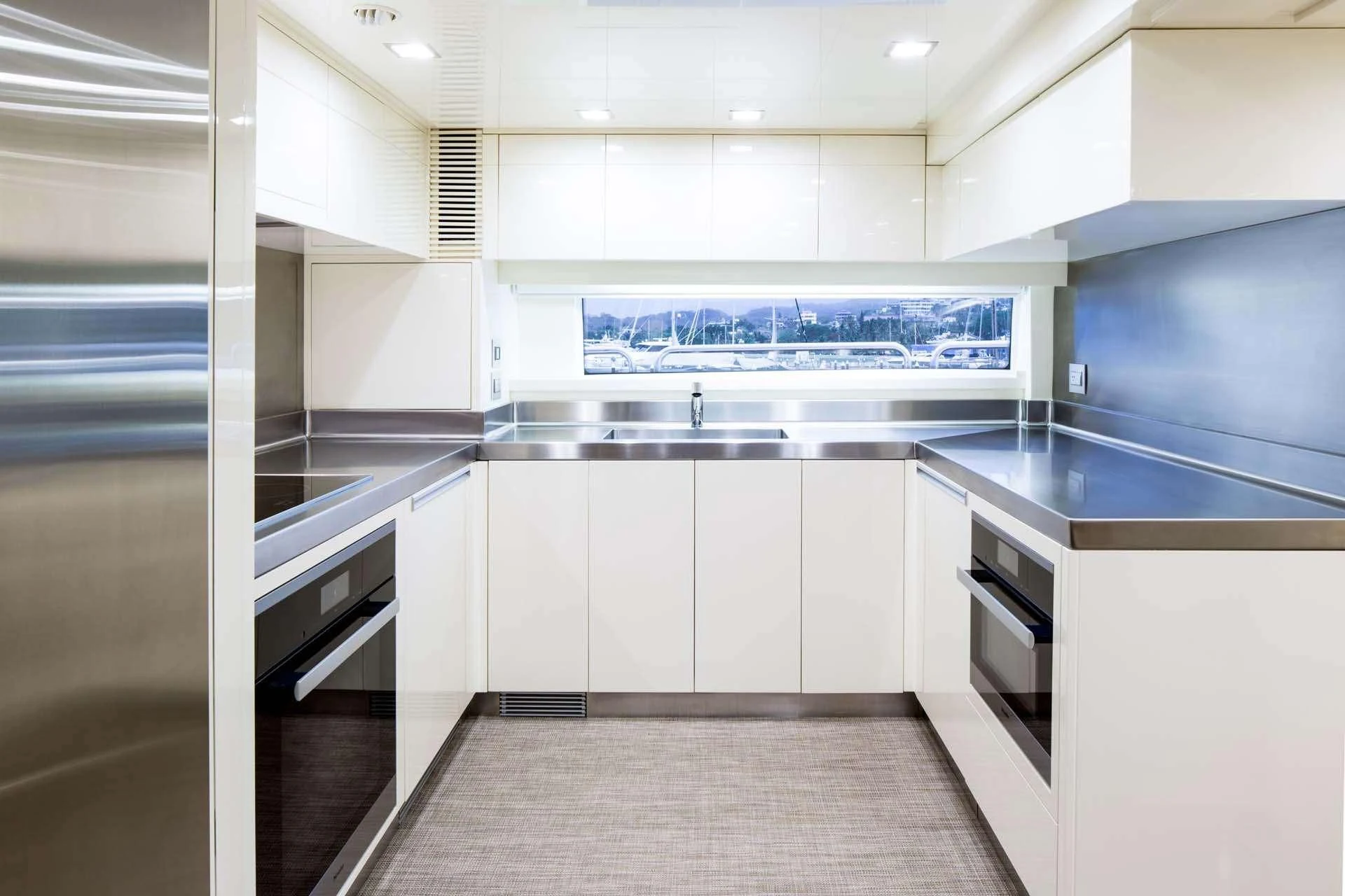 a kitchen with white cabinets aboard AMANECER Yacht for Sale
