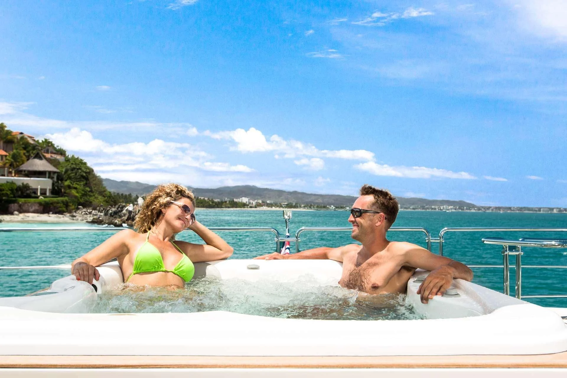 a man and woman sitting on a white boat in the water aboard AMANECER Yacht for Sale