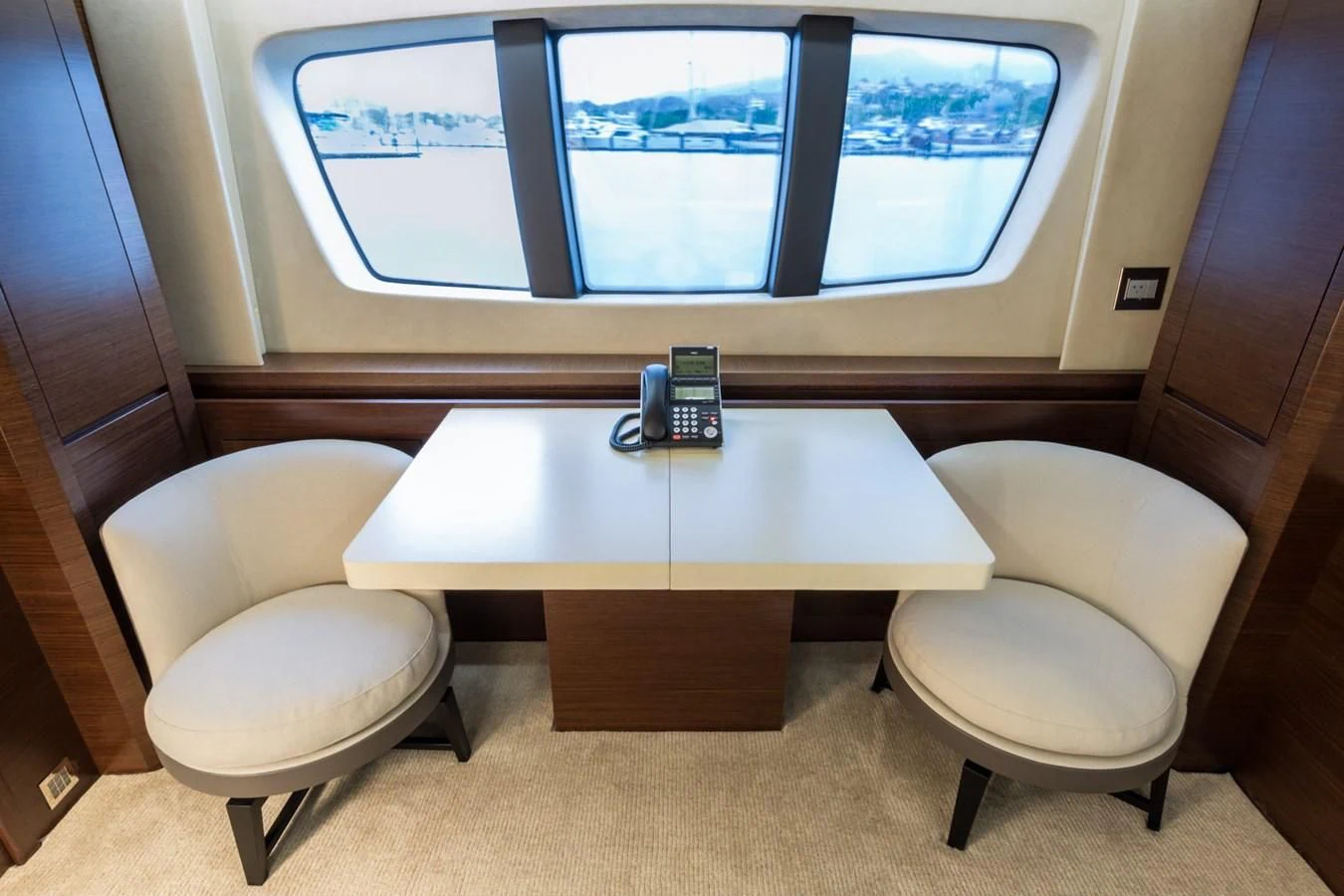a table with chairs and a phone on it aboard AMANECER Yacht for Sale