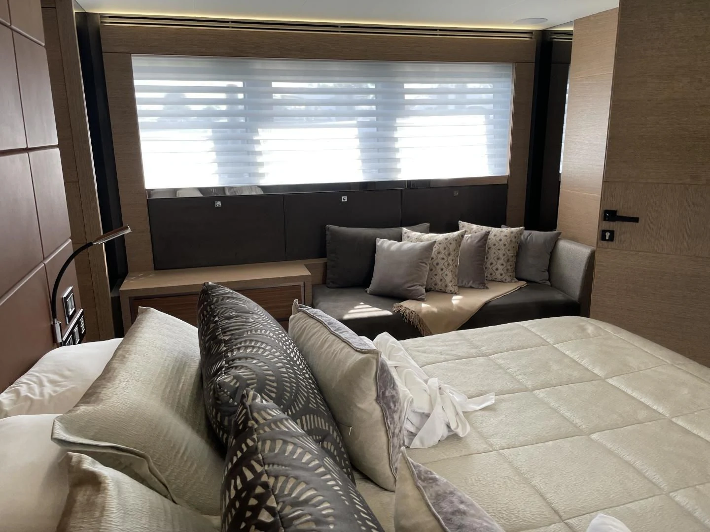 a bed with pillows and a window aboard LEBRADA Yacht for Sale