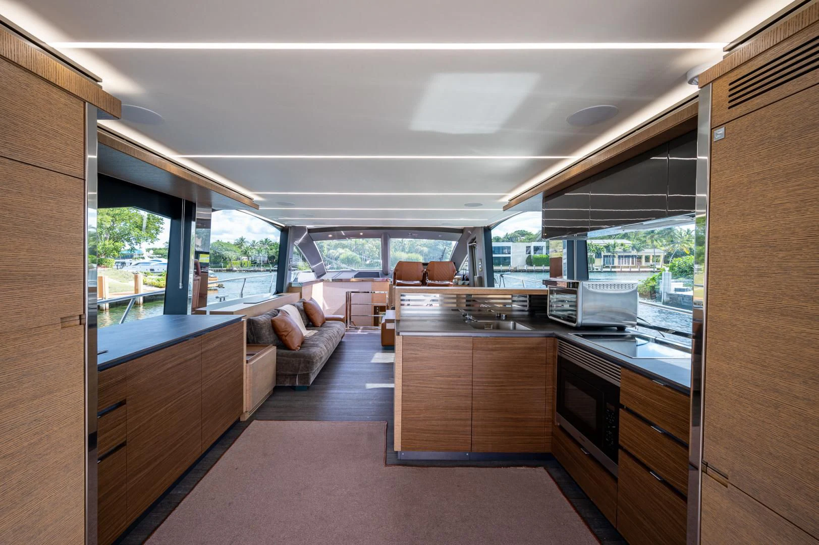 a room with a large window and a kitchen with a view of the city aboard LEBRADA Yacht for Sale