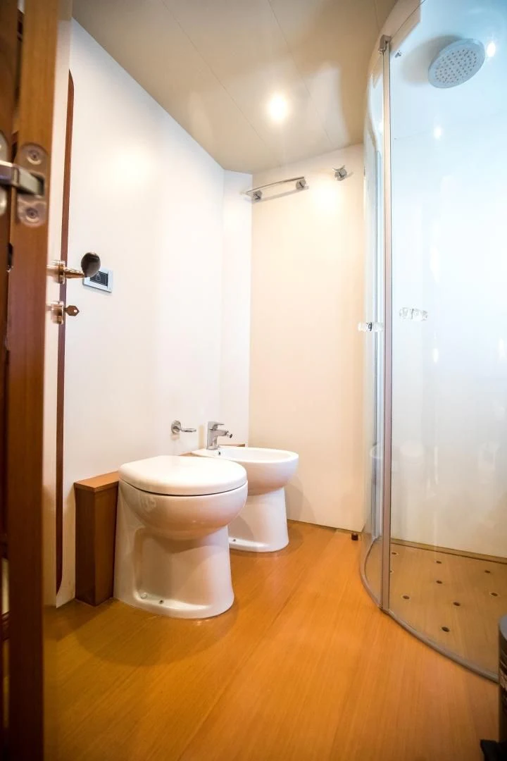 a bathroom with a toilet and a shower aboard TESA Yacht for Sale