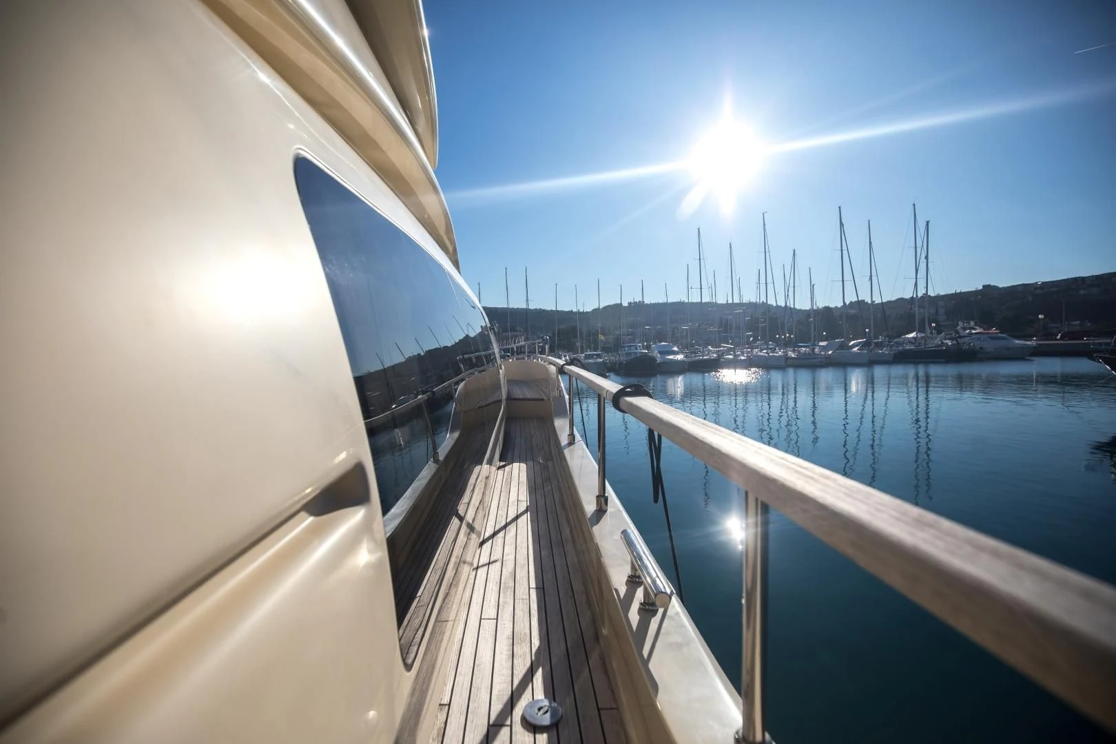 a deck with a railing and a body of water with boats on it aboard TESA Yacht for Sale