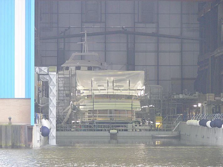 a large building with a lot of windows and a large boat in the water aboard AURORA Yacht for Sale
