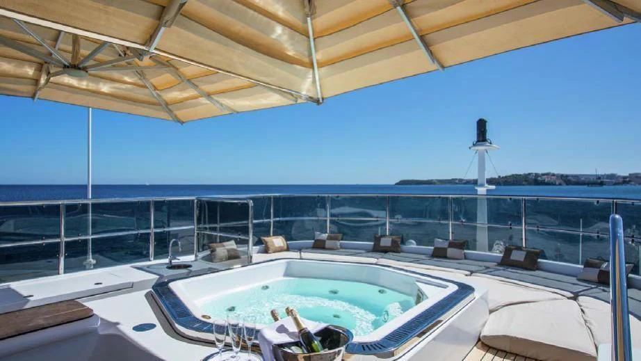 a large pool with a deck and chairs and a large building in the background aboard DIANE Yacht for Charter