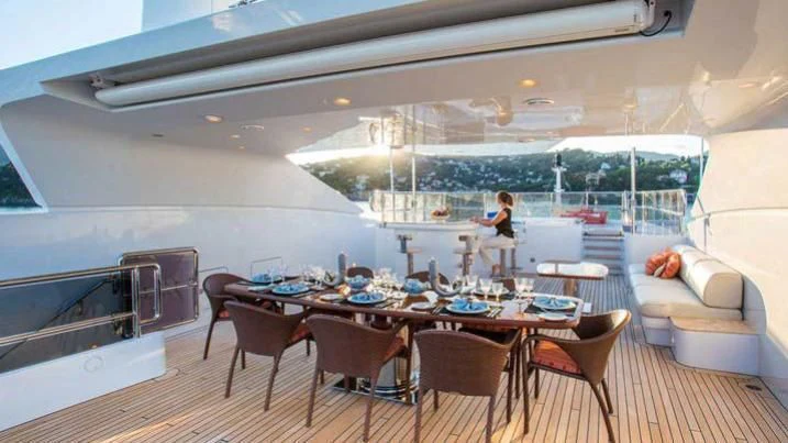 a person sitting at a table in a room with a large window aboard DIANE Yacht for Charter