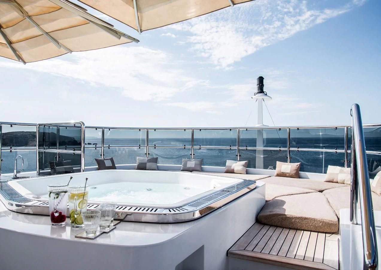 a large white table with chairs and a large white table with a view of the ocean aboard DIANE Yacht for Charter