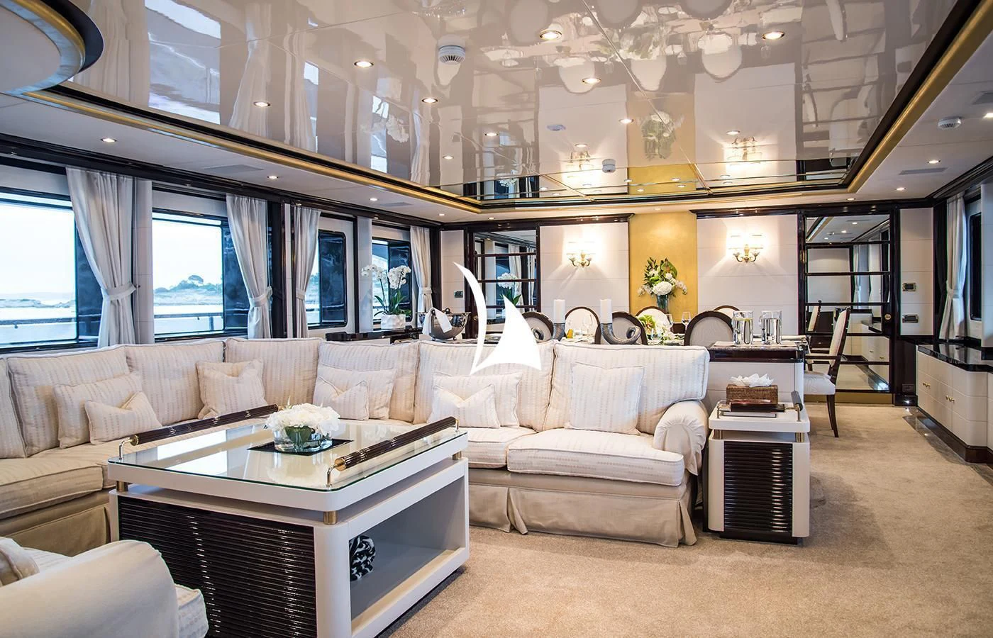 a living room with a large white sofa and a large chandelier aboard DIANE Yacht for Charter