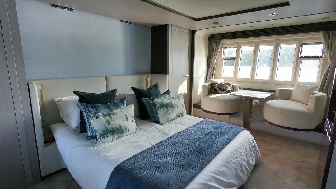 a large bedroom with a bed and a table aboard SOARING Yacht for Sale