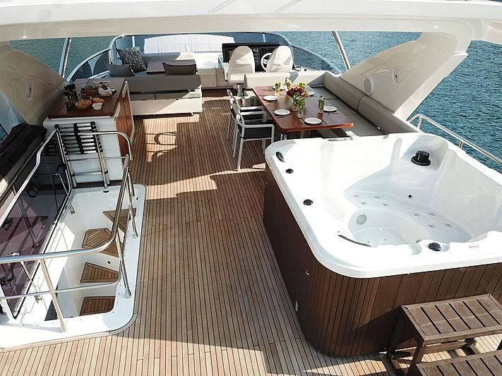 a deck with a table and chairs on it aboard SOARING Yacht for Sale