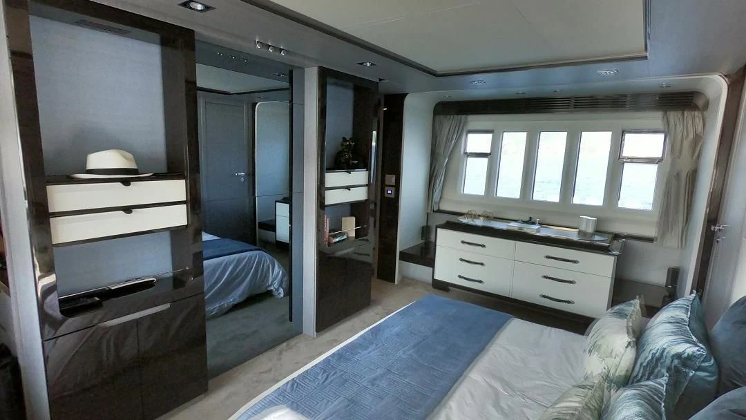 a bedroom with a bed and a dresser aboard SOARING Yacht for Sale