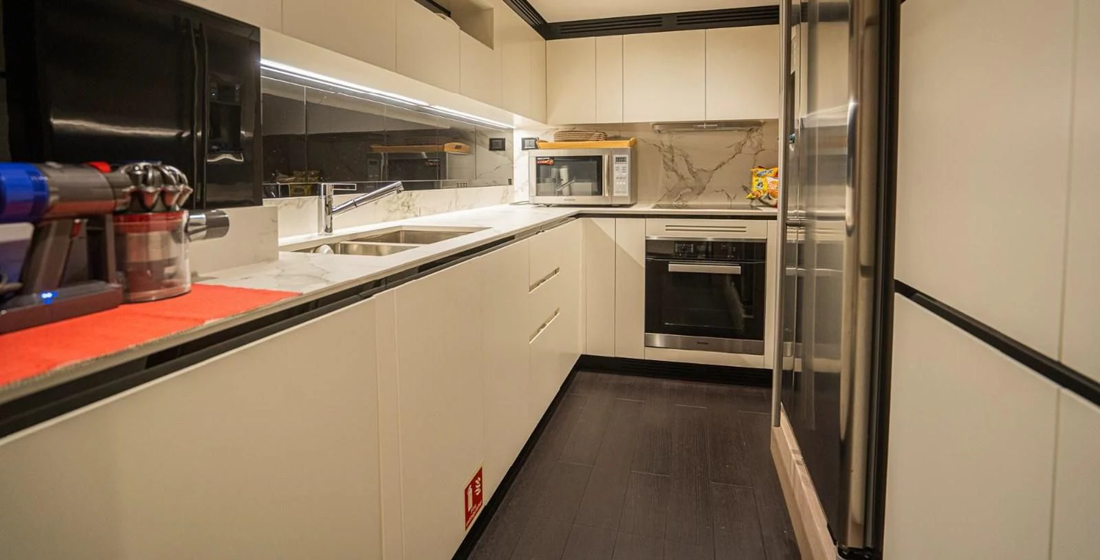 a kitchen with a stainless steel refrigerator aboard LULWA Yacht for Sale