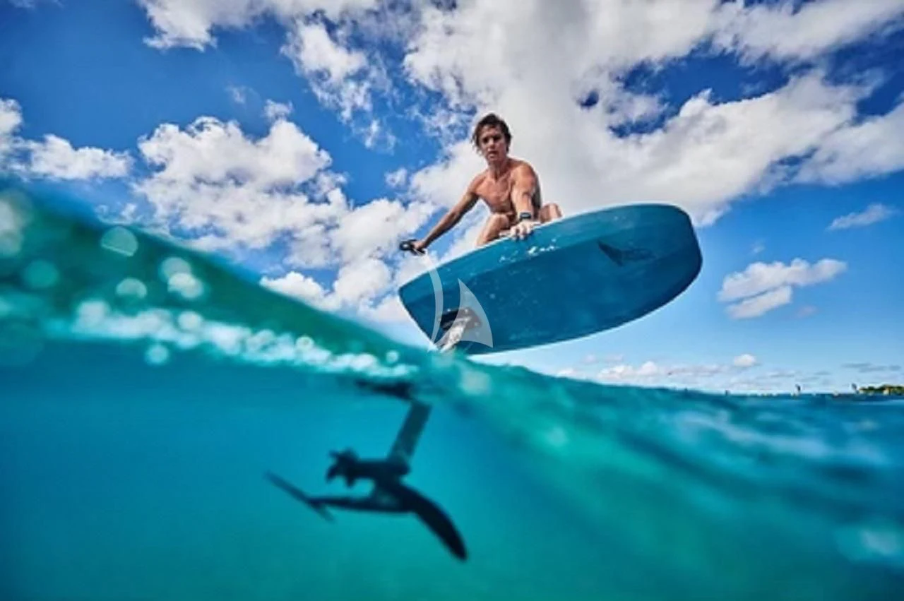 a man riding a surfboard aboard CYNDERELLA Yacht for Sale