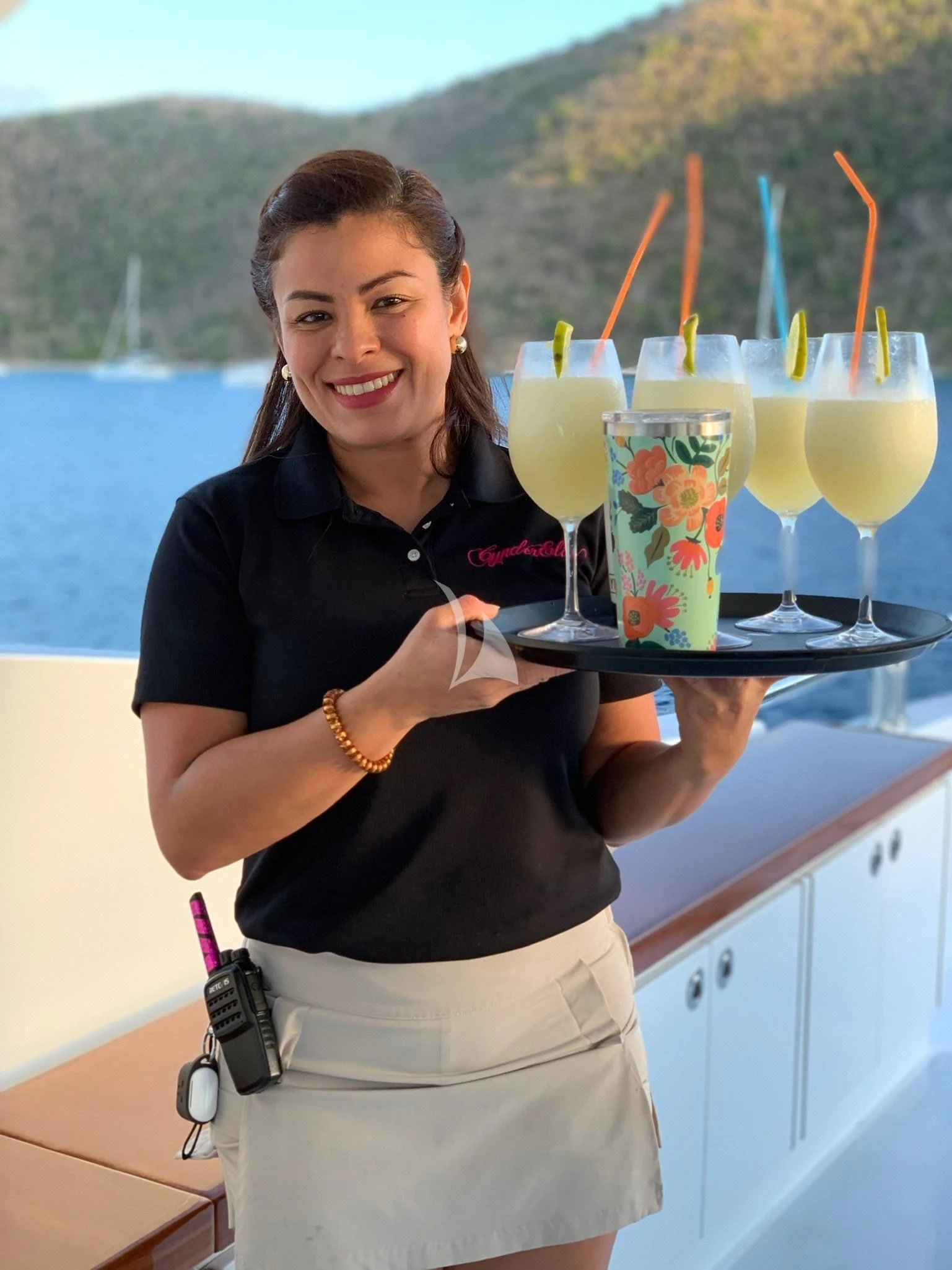 a woman holding a tray of drinks aboard CYNDERELLA Yacht for Sale