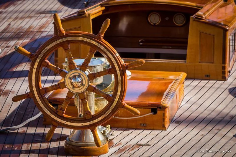 a wooden wheel on a wooden surface aboard MARIQUITA Yacht for Sale