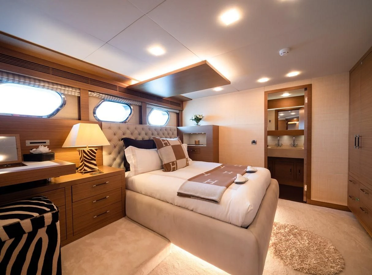 a bedroom with a bed and a desk aboard QHT Yacht for Sale