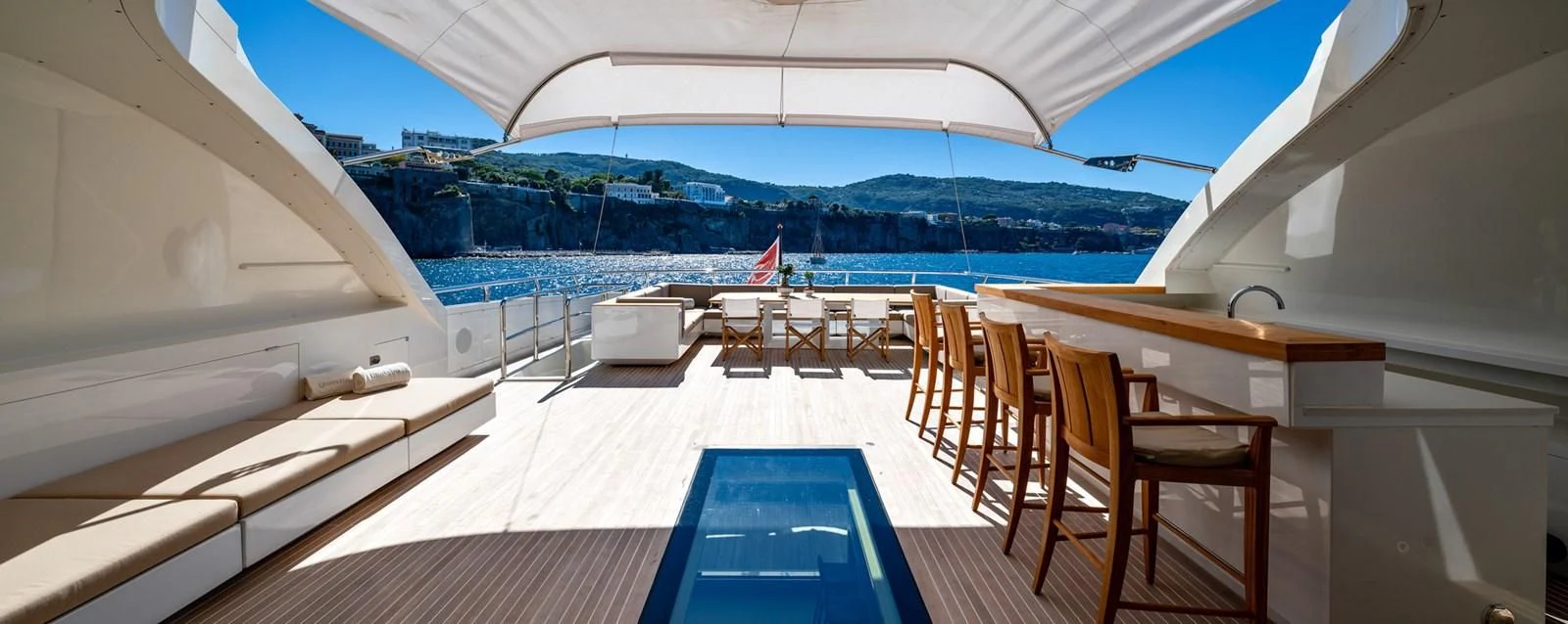 a room with a deck and chairs aboard QHT Yacht for Sale